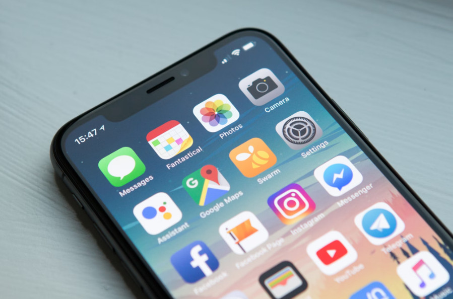 A person planning their application for a free government iPhone with a phone and documents on a desk