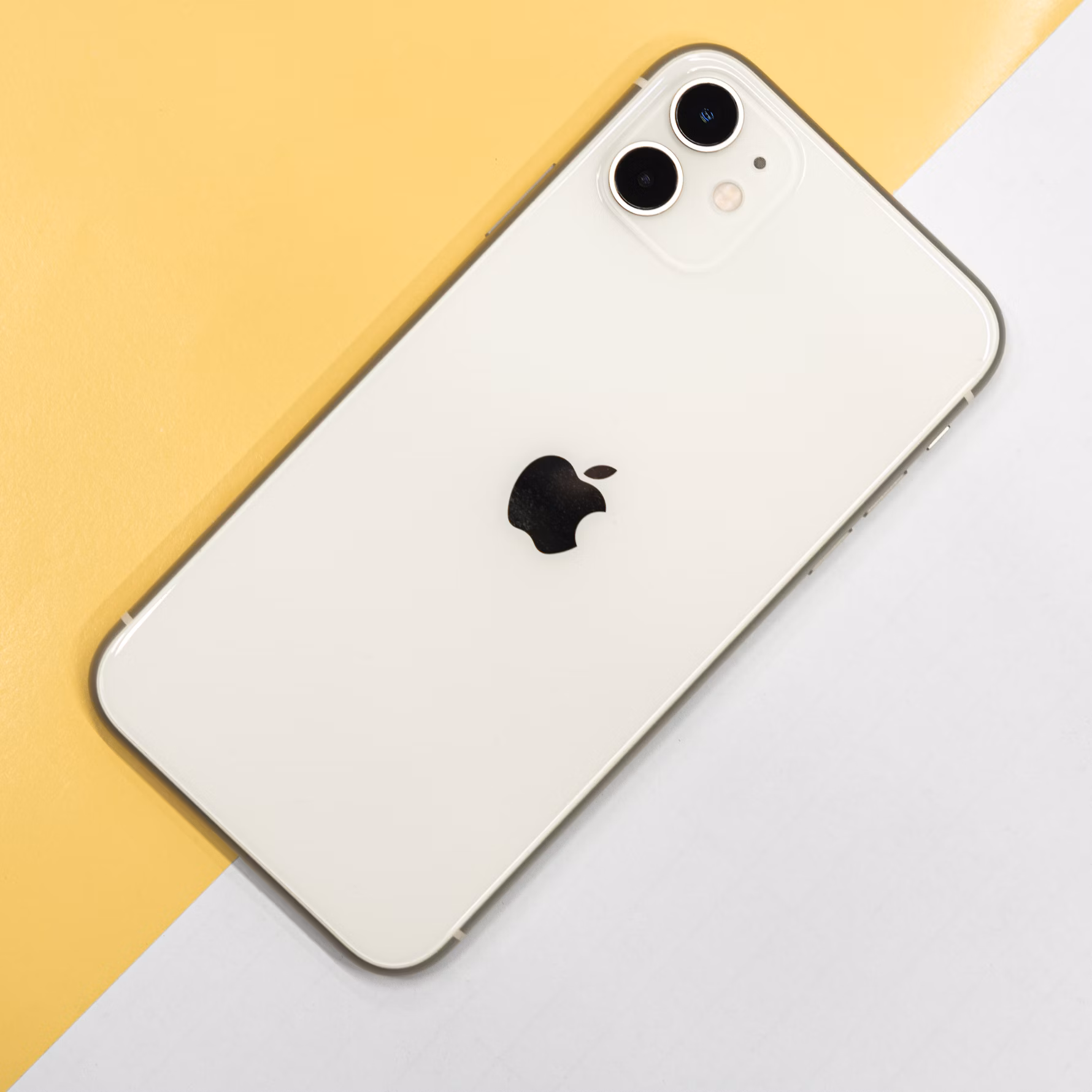 A smiling person holding a new iPhone, feeling connected and happy